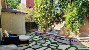 A patio with stone tiles and artificial grass, a small pool, and a seating area with cushions. - A Luxury Home with Pool, Spa, and Mini-golf (Los Angeles)
