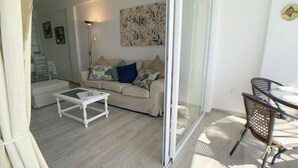 Ein Wohnzimmer mit einer Couch, einem Couchtisch und einem Essbereich mit Stühlen.