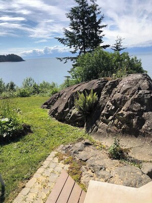 A rocky landscape with a clear view of a body of water and a distant island.
