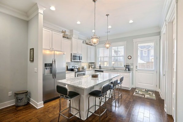 Enjoy cooking in this well-lit kitchen with a central island and stainless steel appliances.