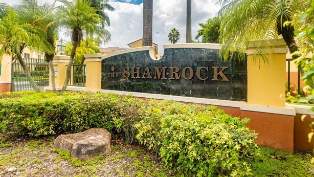 A sign for 'The Shambock' with a landscaped entrance featuring palm trees and a stone pathway. - Charming Kendall Home in Miami (Miami)