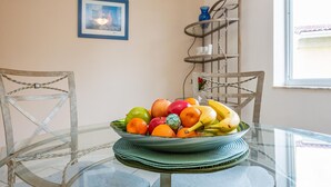 A dining area with a glass table, chairs, and a fruit bowl. - Charming Kendall Home in Miami (Miami)