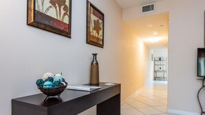 A reception desk with a vase and decorative bowl, framed artwork on the wall, and a TV on the right. - Charming Kendall Home in Miami (Miami)