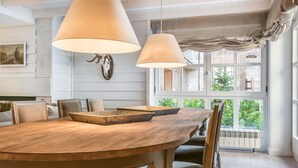 A dining area with a wooden table, chairs, and hanging lamps. - Val de Ruda Luxe 20 by FeelFree Rentals (Val de Ruda)