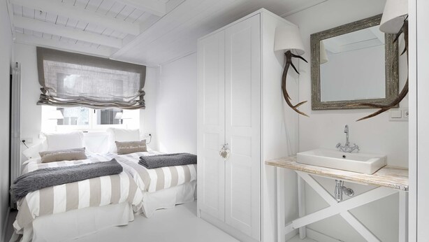 A bedroom with a bed, bedside tables, a wardrobe, a bathroom with a sink and mirror, and a window with curtains. - Val de Ruda Luxe 20 by FeelFree Rentals (Val de Ruda)