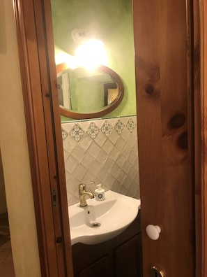 Bathroom features a sink, mirror, and tiled wall.