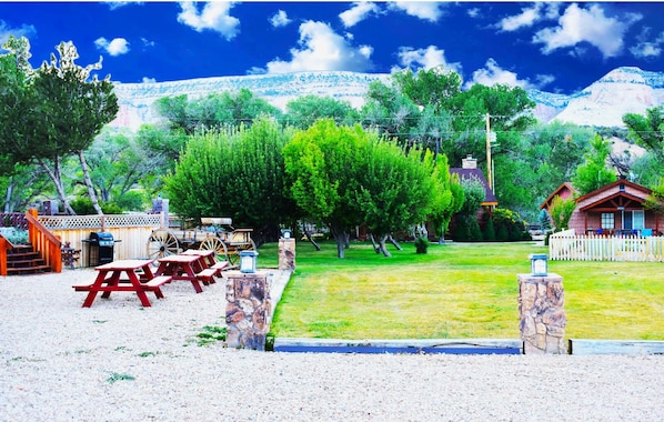 Enjoy a serene outdoor space with a picnic table, benches, and a charming wooden structure.