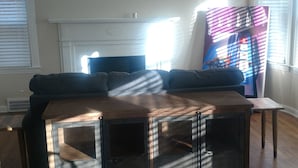 Un salon équipé d’un ventilateur de plafond, d’un canapé d’angle, d’une table basse et d’un téléviseur.