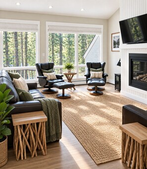 A modern living room with a sectional sofa, two leather armchairs, a coffee table, and a fireplace.