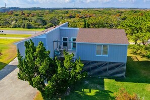 A two-story house with a balcony, a garage, and a driveway. - 386 Unique Ocean-Side Home - 4 Lots from Ocean! (Nags Head)
