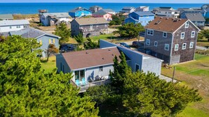 A coastal residential area with houses, a dock, and a clear view of the ocean.