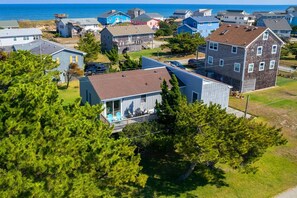 Zona residencial costera con casas, un muelle y una vista despejada del océano.
