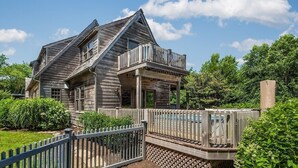 A rustic wooden house with a balcony and a wooden deck.