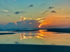 A beach with a sunset, calm water, and a distant lighthouse. - El Matador 311 by Alicia Hollis Rentals FREE BEACH SERVICE! (Fort Walton Beach)