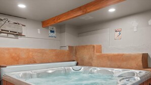 Ein Whirlpool mit Holzverkleidung und einem Holzbalken an der Decke.