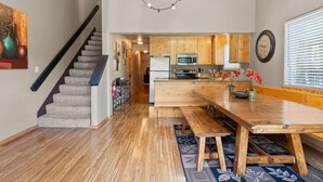 Eine moderne Küche mit Holzausbau, einer eingebauten Mikrowelle und einem Essbereich mit einem Holztisch und Bänken.