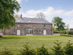 A stone building with a large front door, multiple windows, and a sloped roof. - The Stables - UK11108 (Montrose)