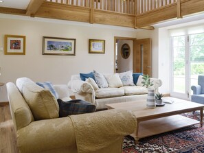 A living room with two sofas, a coffee table, and a large window. - The Stables - UK11108 (Montrose)
