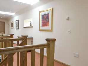 A hallway with wooden railings, a staircase, and framed artwork on the walls. - The Stables - UK11108 (Montrose)