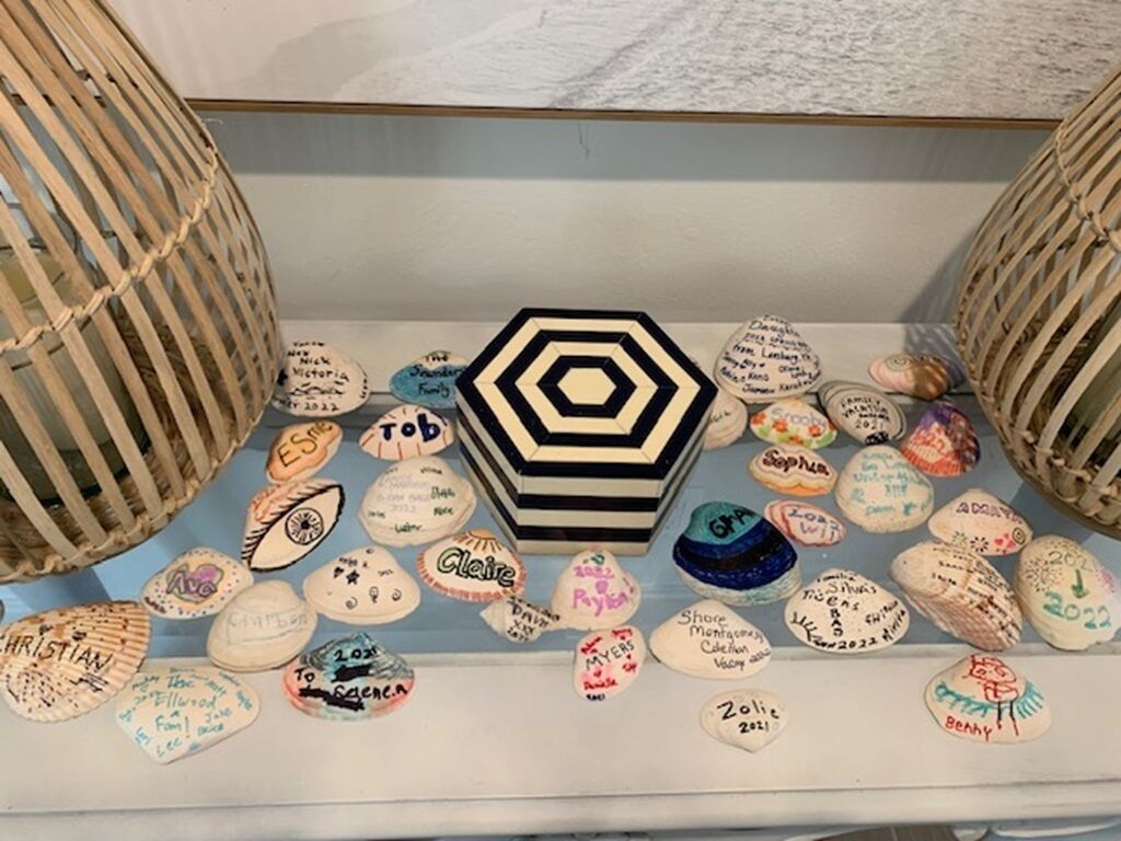 Una exhibición de conchas marinas con nombres y fechas, rodeada de cestas tejidas.