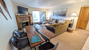 Living room with sofa bed, wood fireplace, and balcony w/ propane BBQ grill