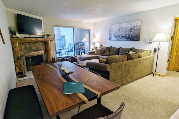 Living room with sofa bed, wood fireplace, and balcony w/ propane BBQ grill
