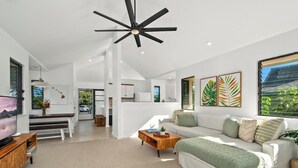A modern living room with a large sofa, a coffee table, and a TV.