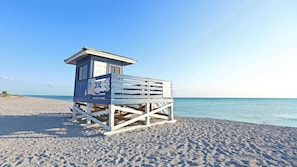 A wooden lifeguard tower on a sandy beach with clear blue water in the background. - Lovely cottage close to beach (Nokomis)