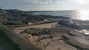 A rocky shoreline with a concrete pathway leading to the water. - L'Eclose - Cap Marine, gîte in Guilvinec (Guilvinec)