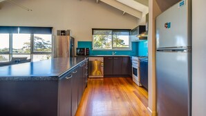 A modern kitchen with stainless steel appliances, a dishwasher, and a window providing a view of the outdoors. - Raywood - sleeps up to 17 (COWES)