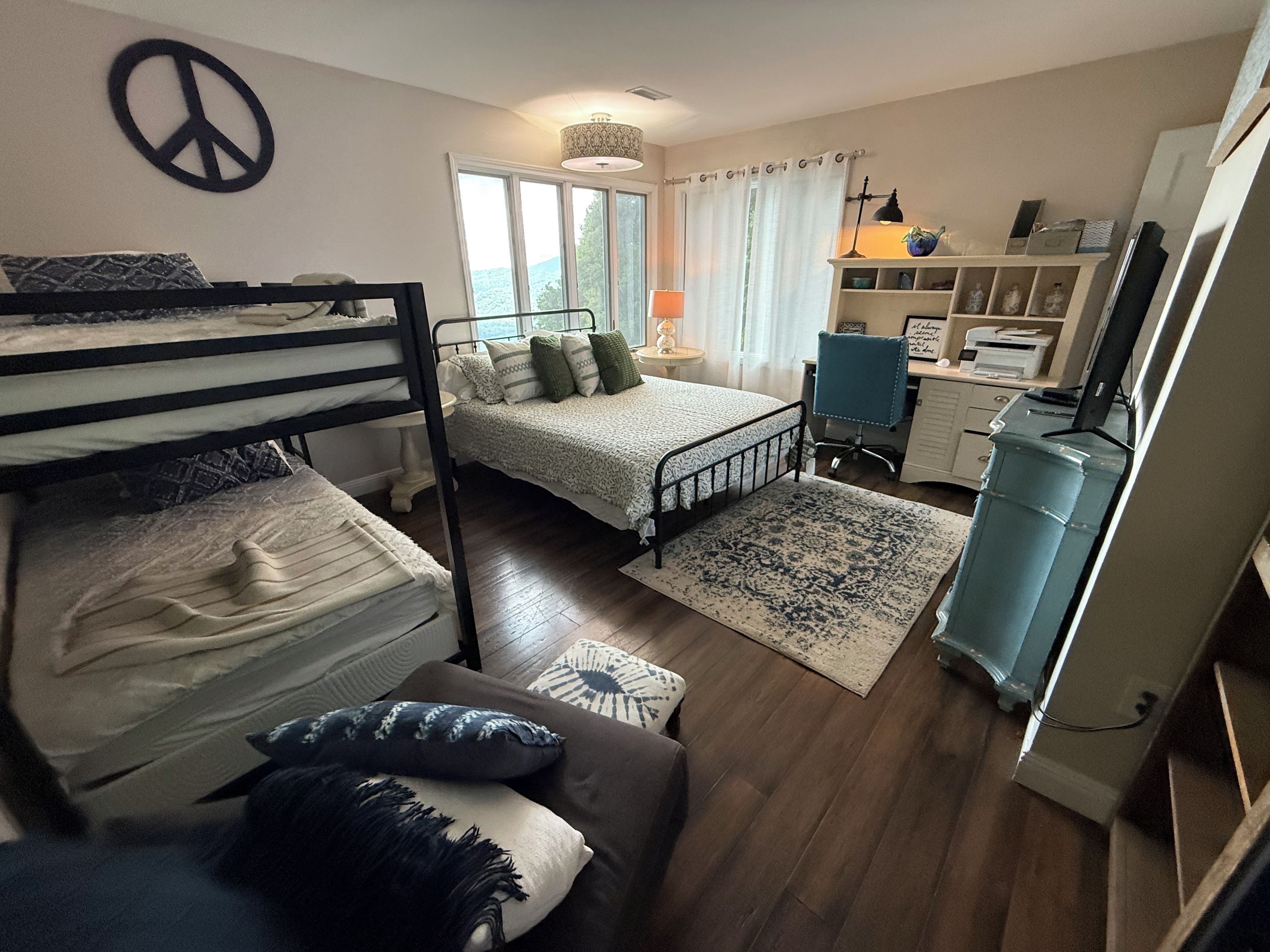 Une chambre avec des lits superposés, un bureau et une chaise.