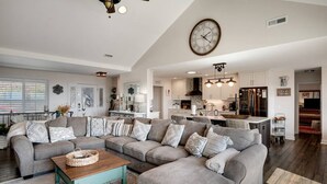 A modern living room with a sectional sofa, a wooden coffee table, and a kitchen in the background. - High Heaven Mountain top dream (Sapphire)