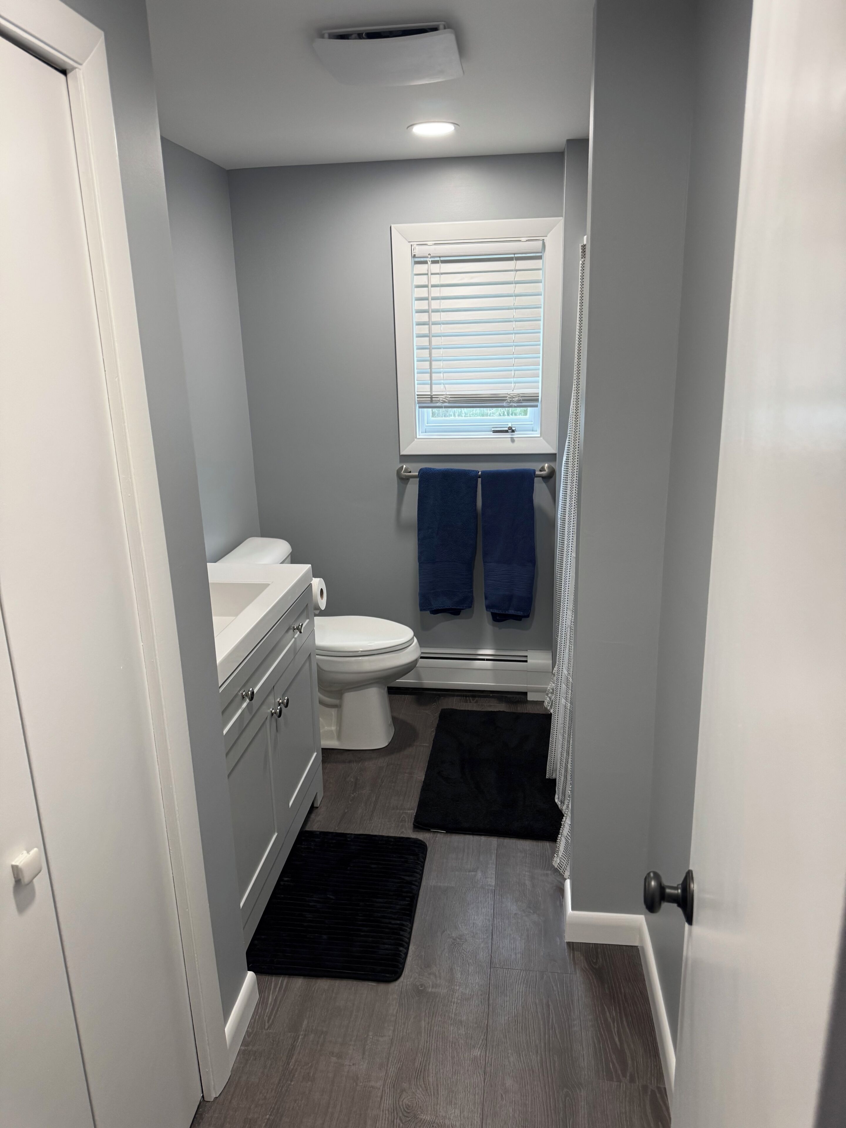 Un baño pequeño con inodoro, lavamanos y ventana.