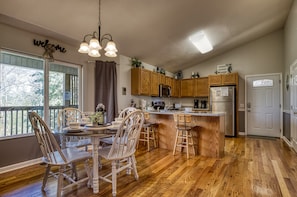 Enjoy meals and social gatherings in this spacious kitchen and dining area, featuring a large island and dining table.