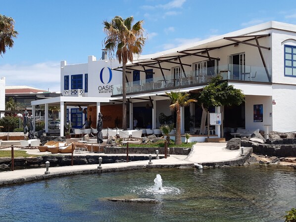 A two-story building with a pool and outdoor seating area. - Luxury House With Large Communal Pool, Close to Marina and Beaches (Residencial Iris Fase II)