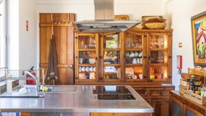 A kitchen with a stainless steel island, wooden cabinets, and a large window.