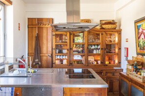 A kitchen with a stainless steel island, wooden cabinets, and a large window.