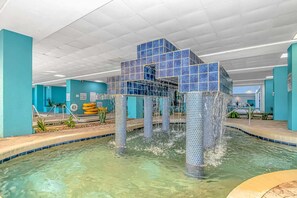A pool with a unique tiled structure in the center, surrounded by turquoise walls and a clear pool area.