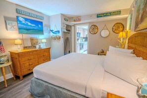 A bedroom with a bed, dresser, and wall decorations including a 'STRESS FREE ZONE' sign.
