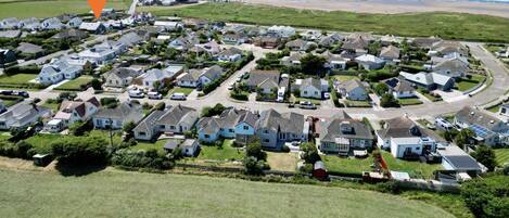 A residential area with houses and a road leading to a beach.