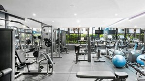 A modern gym with various exercise equipment, including weight machines, treadmills, and exercise balls. - 250m from the beach.Gym/lap pool access,Parking, pet friendly, outdoor area, BBQ (Port Melbourne)