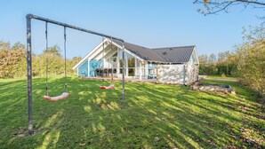A house with a swing set in the yard. - Gorgeous home in Hemmet with sauna (Hemmet)
