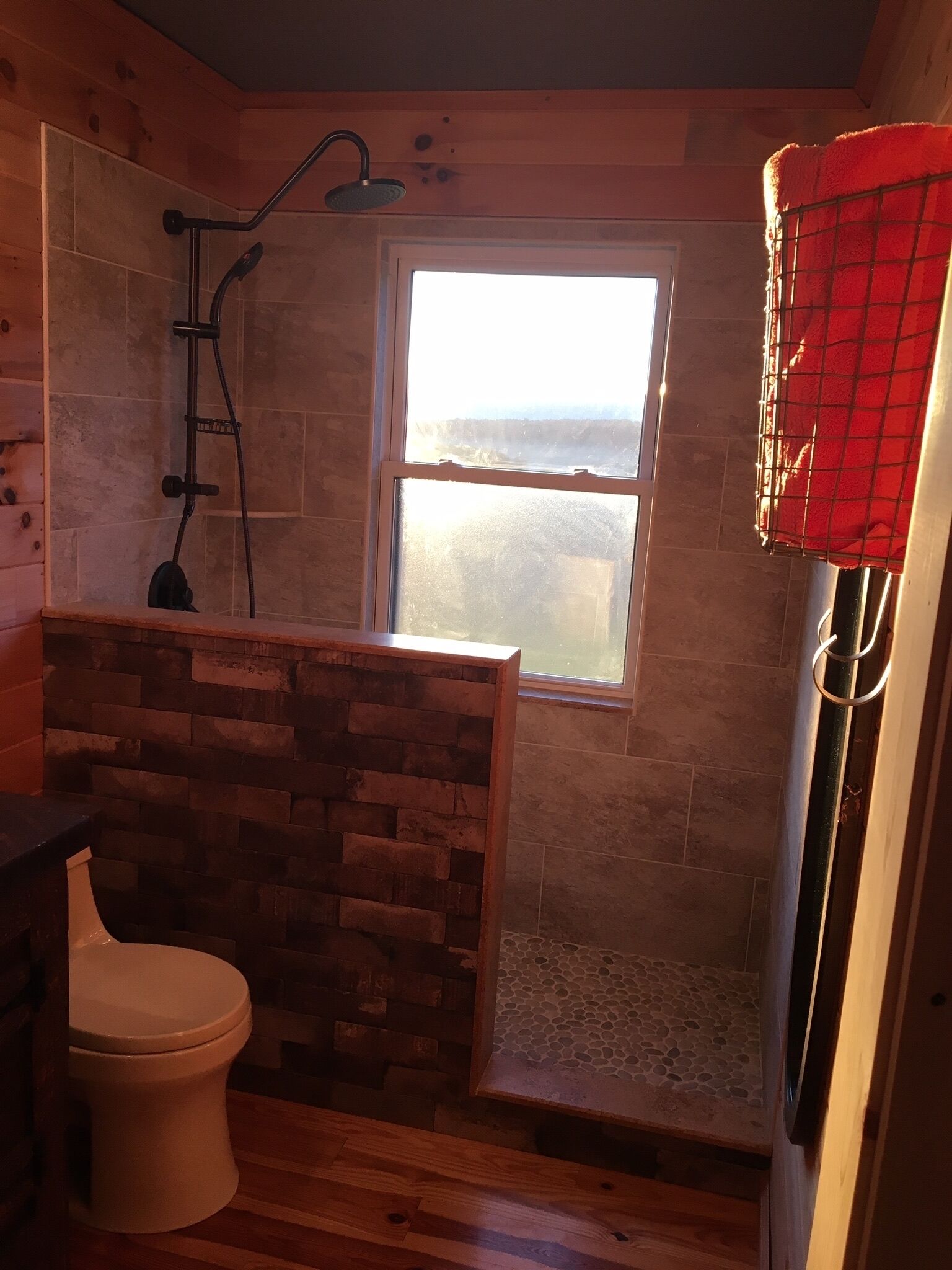 Un baño pequeño con ducha, inodoro y ventana.