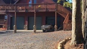 A two-story building with a balcony, a covered parking area, and a gravel driveway. - THE HAY LOFT in the Beautiful Shenandoah Valley (Mt Jackson)