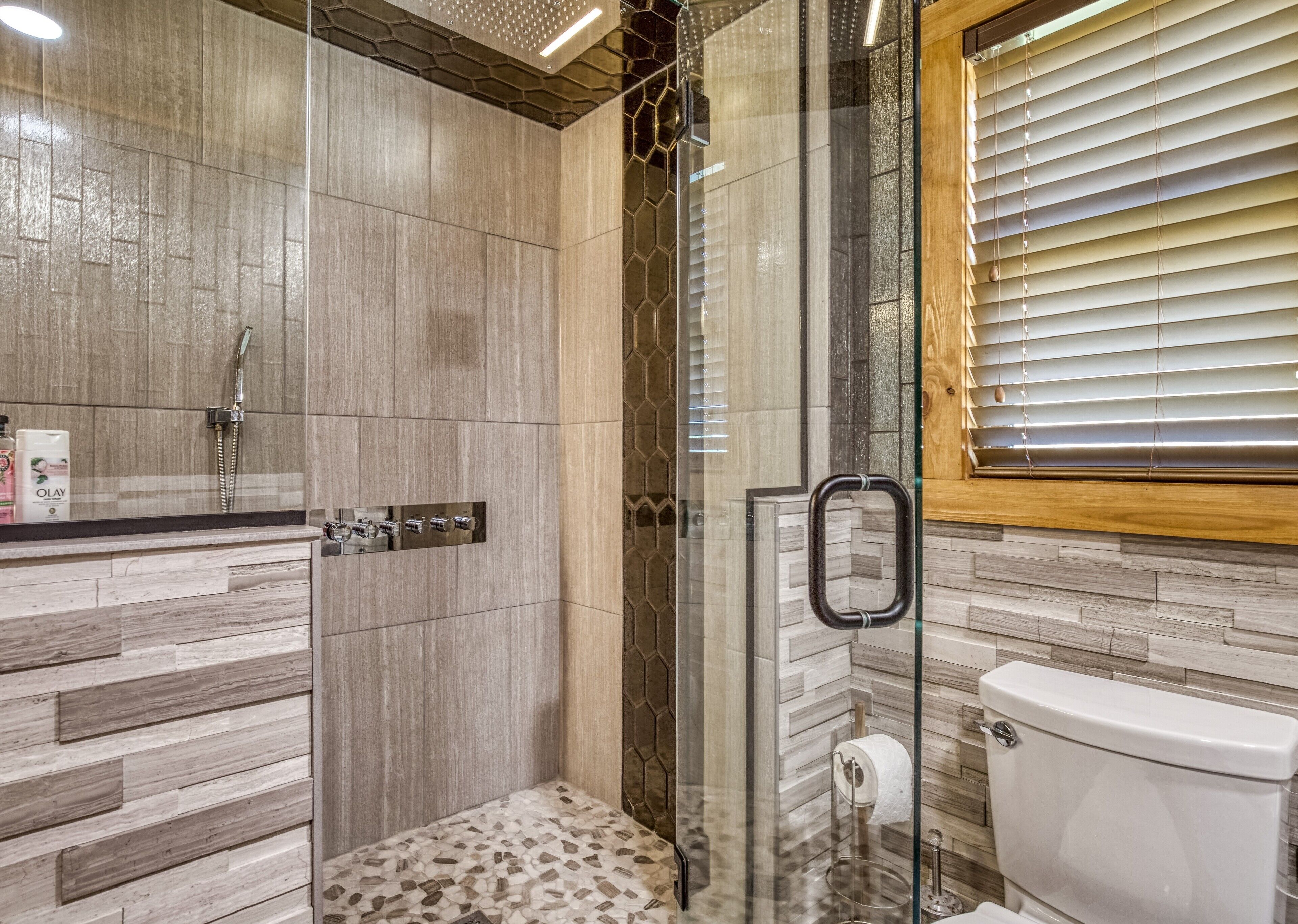 A modern bathroom with a shower, toilet, and vanity.