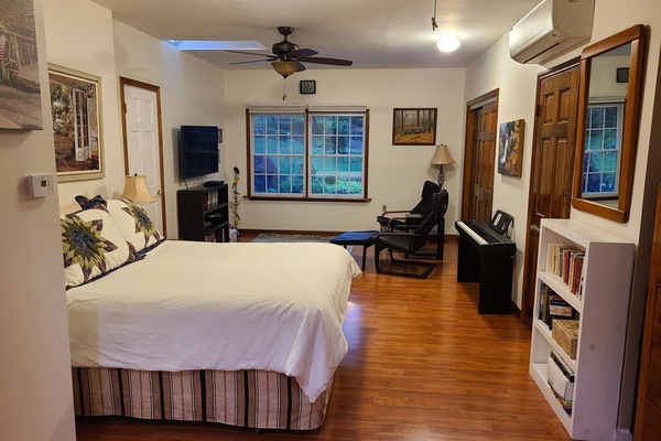 Large bedroom with queen bed ,TV and chairs