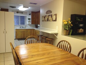 A kitchen with wooden cabinets, a dining table with chairs, and a kitchen island. - 2BlocksTo Southern Utah University SUU, Summer Games, Shakespeare! Sleeps 4 -15 (Cedar City)