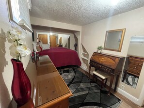 A bedroom with a bed, dresser, vanity, mirror, and a vase with flowers. - 2BlocksTo Southern Utah University SUU, Summer Games, Shakespeare! Sleeps 4 -15 (Cedar City)