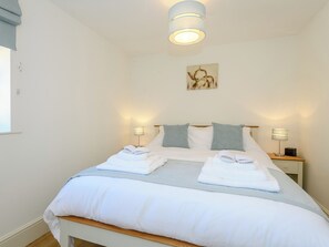A neatly made bed with white linens, two bedside lamps, and a wall-mounted artwork. - 3 bedroom accommodation in Fulletby, near Horncastle (Fulletby, near Horncastle)