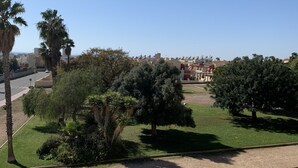 Un quartiere residenziale con vista libera su una strada, un prato verde e una fila di case.
